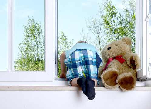 Junge beugt sich aus dem Fenster