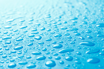 Close-up of fresh water drops on blue surface