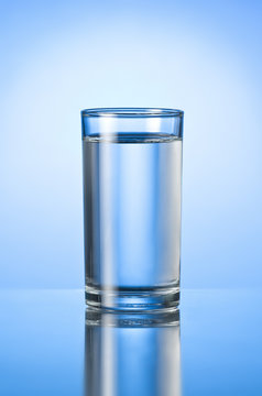 glass of pure water on blue glossy background