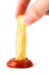 French fry being dipped in ketchup