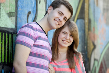 Young couple near graffiti background.