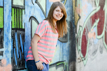 Naklejka premium Style teen girl near graffiti wall.
