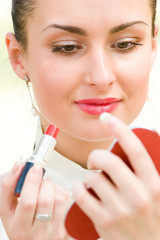 Pretty woman applying cosmetics