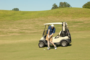 Golfer taking a swing at the ball down the fairway