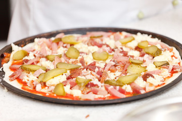 chef making pizza at kitchen
