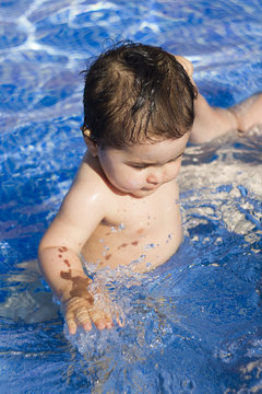 Newborn baby enjoying the summer in the pool