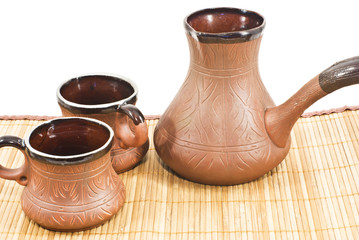 two brown ceramic coffee cup filled  and ceramic coffee maker
