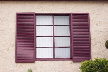 Red window on rough wall