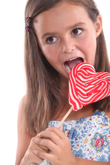 Girl about to lick a heart lollipop