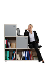 Woman sitting on a modern bookcase