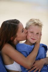 Fototapeta premium Woman kissing her son on a beach