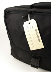 black travel bag and lost property tag
