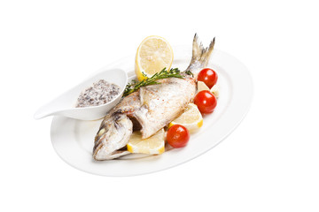 grilled fish with tomato, lemon and sauce on plate