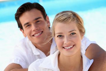 Obraz premium Smiling young couple with a blue sky background