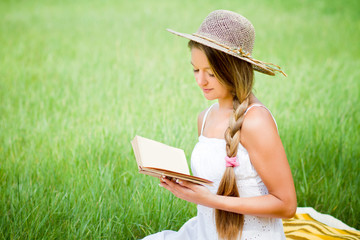 young beautiful girl with book in nature