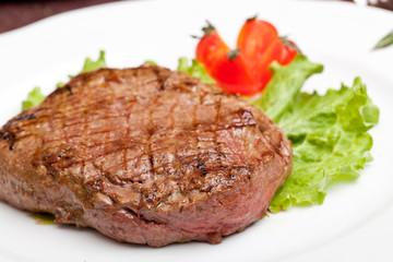 Grilled steak on a white plate