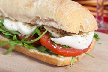 Sandwich with arugula, tomatoes and mozzarella
