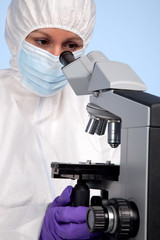 Biochemist looking through a microscope