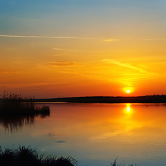 Obraz na płótnie Canvas red sunset over river