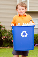 Recycling concept with young child carrying recycling bin