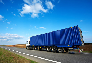Fototapeta premium Red lorry with grey trailer over blue sky