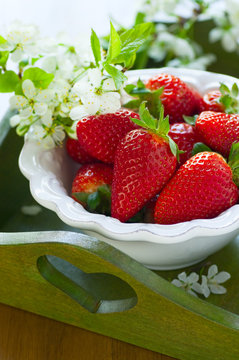 Strawberries in white bowl on a tray