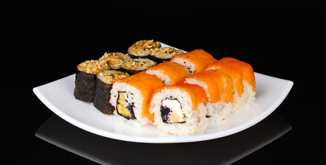 Tasty rolls served on white plate isolated on black