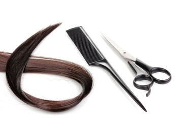 Shiny brown hair with hair cutting shears and comb isolated