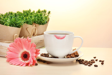 cup of coffee with lipstick mark and gerbera beans, cinnamon