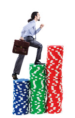 Businessman climbing stacks of casino chips