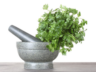 Parsley in a mortar and pestle on wooden