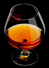 cognac in glass isolated on black background