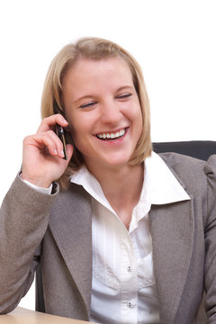 Junge moderne Gesch&auml;ftsfrau lachend an ihrem Mobiltelefon