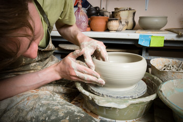 hands of a potter, creating an earthen jar on the circle