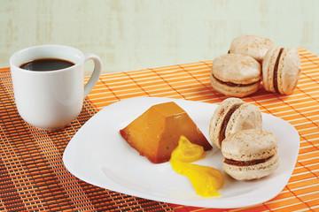 Cup of coffee, macaroons and caramel pudding