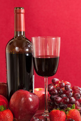 Obraz premium Red wine bottle and fruit with glass