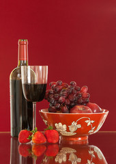 Red wine bottle and fruit with glass