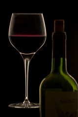 Rotwein im Glas mit Flasche