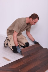 handyman laying floorboards