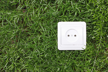 electric power receptacle on a green grass background