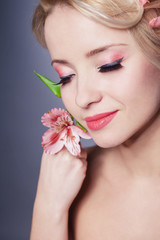 Obraz na płótnie Canvas young beautiful woman with pink flower