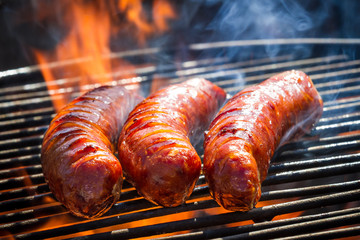 BBQ with fiery sausages on the grill - obrazy, fototapety, plakaty
