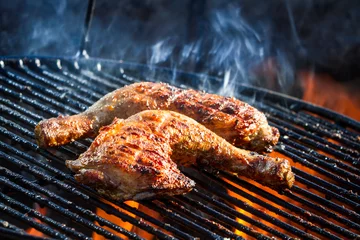 Gartenposter Flames frying chicken on the grill © shaiith