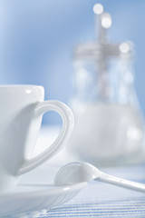 white ceramic coffee cup and spoon and sugar bowl