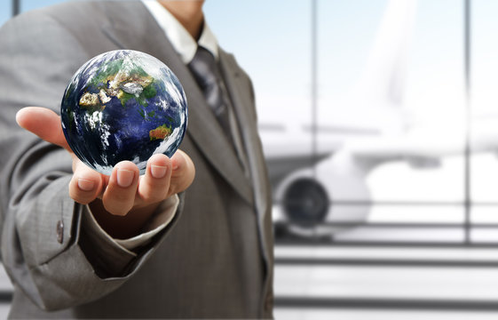 business man holds globe in the airport"Elements of this image f