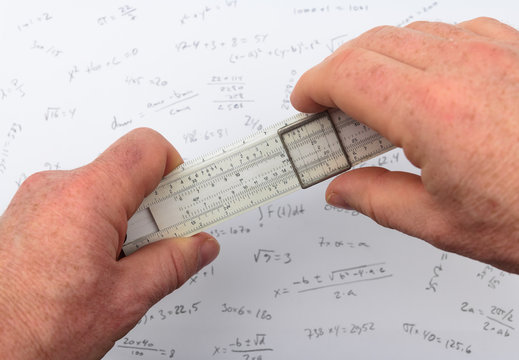 person calculating on a slide rule