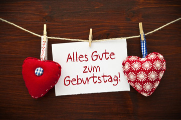 2 Stoffherzen mit Alles Gute auf Holzbrett