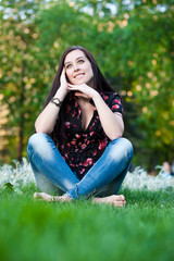 Fototapeta premium happy pretty girl sitting on the grass