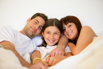 Fototapeta premium Couple and daughter in bed