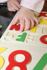 Little kid playing with letter puzzle © auremar